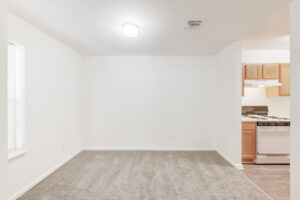 Interior Unit Dining Area, neutral toned carpeting, wood-like floors in kitchen, ceiling light.