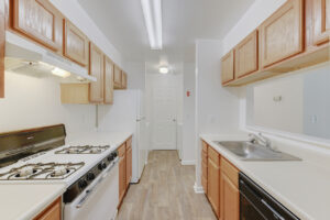 Interior Unit Kitchen, laminate countertops, light brown cabinetry, wood like floors, white walls.